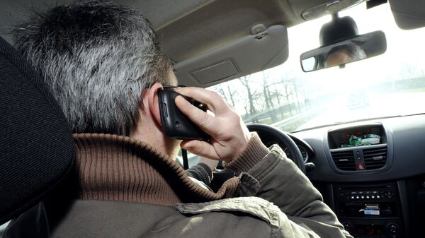 Мужчина разговаривает по телефону за рулем автомобиля