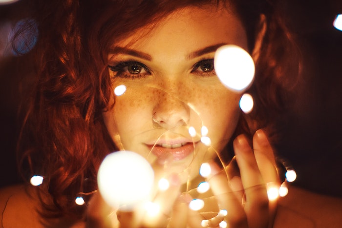 A female model holding fairy lights as DiY photography lighting