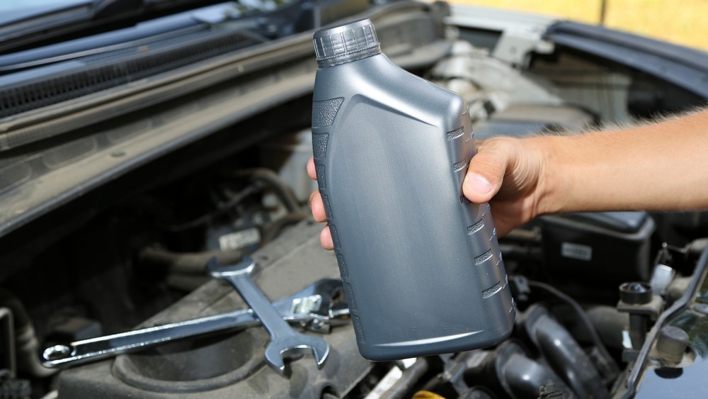 Auto mechanic hand holding motor oil