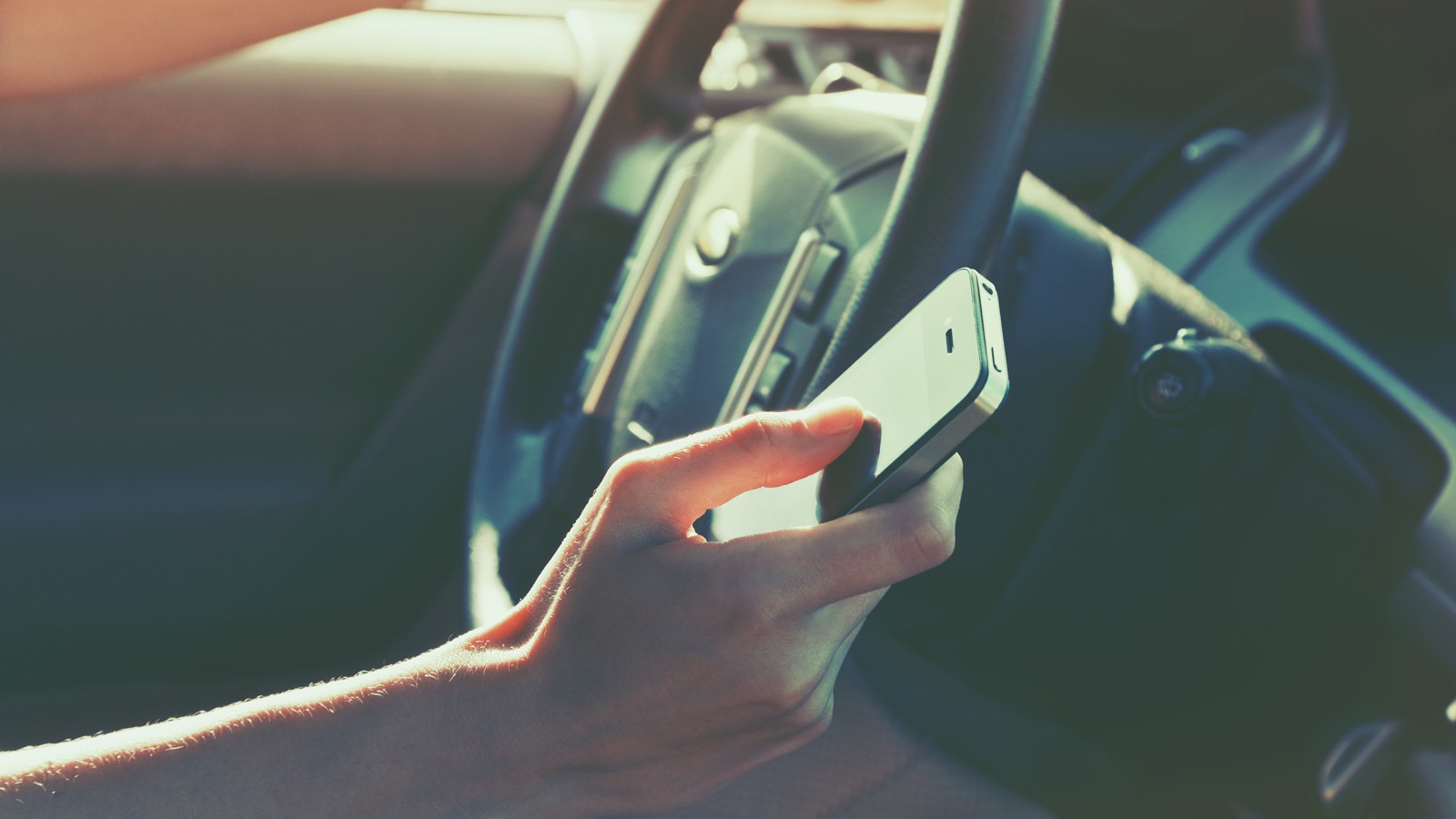 girls hand using smart phone while car driving